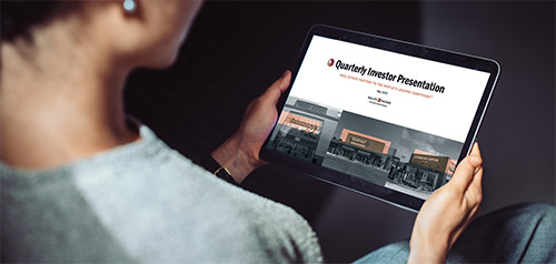 A person holding a tablet device displaying the investor presentation.