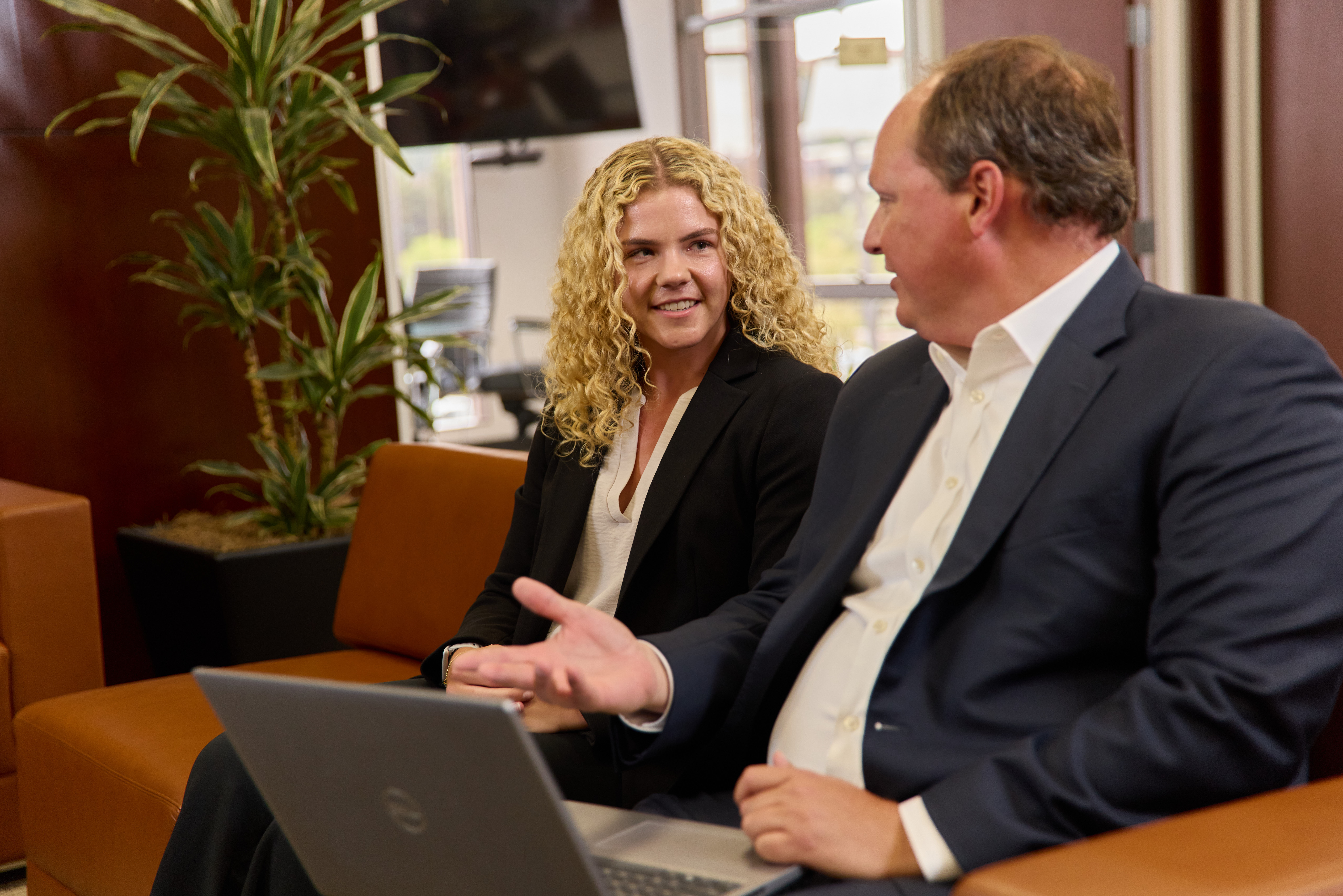 two colleagues, a man and a woman, having a conversation while seated