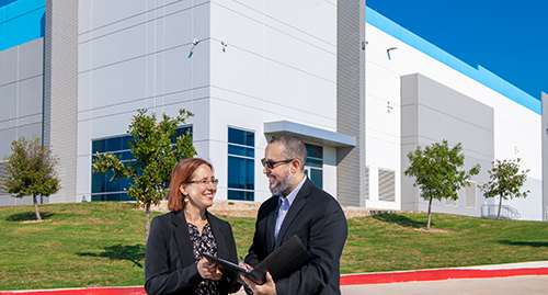 People talking in front of a warehouse