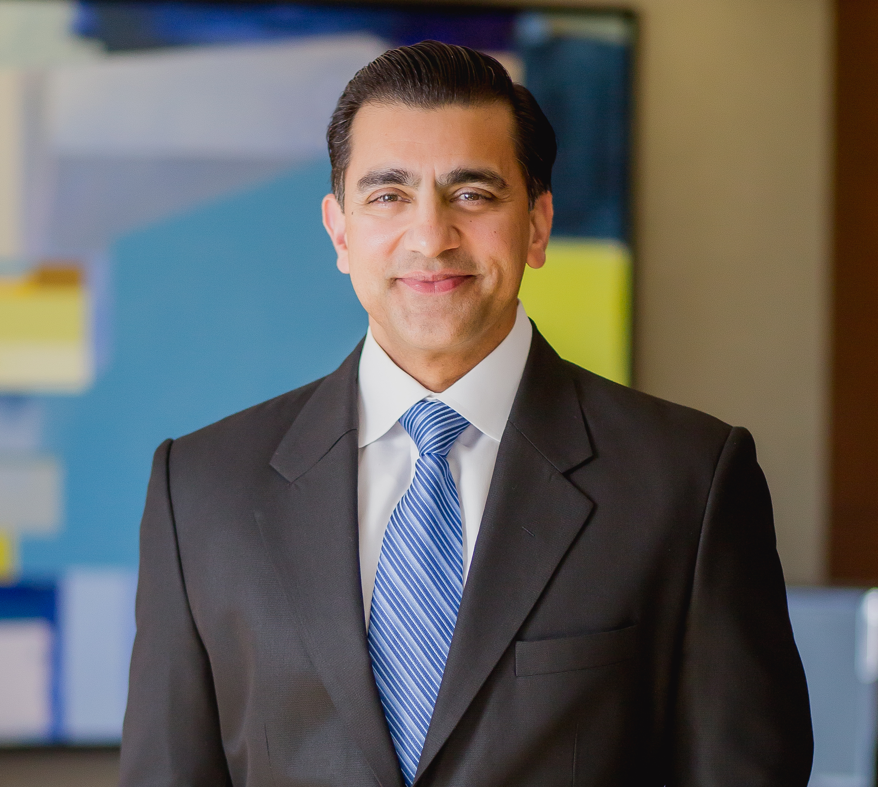 The company's CEO smiles in his office. 