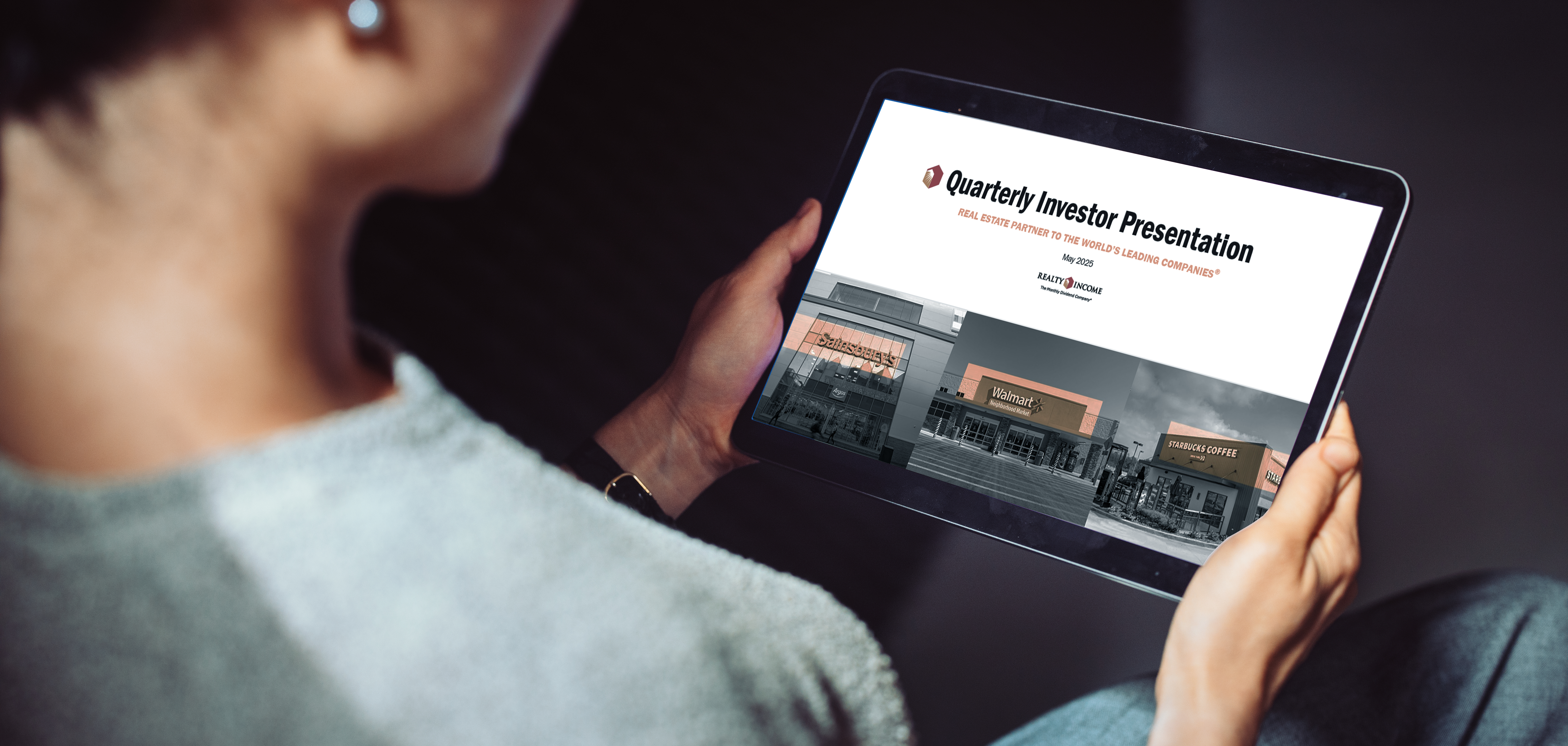 A person holding a tablet device displaying the investor presentation. 