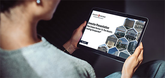 A person holding a tablet device displaying the investor presentation.